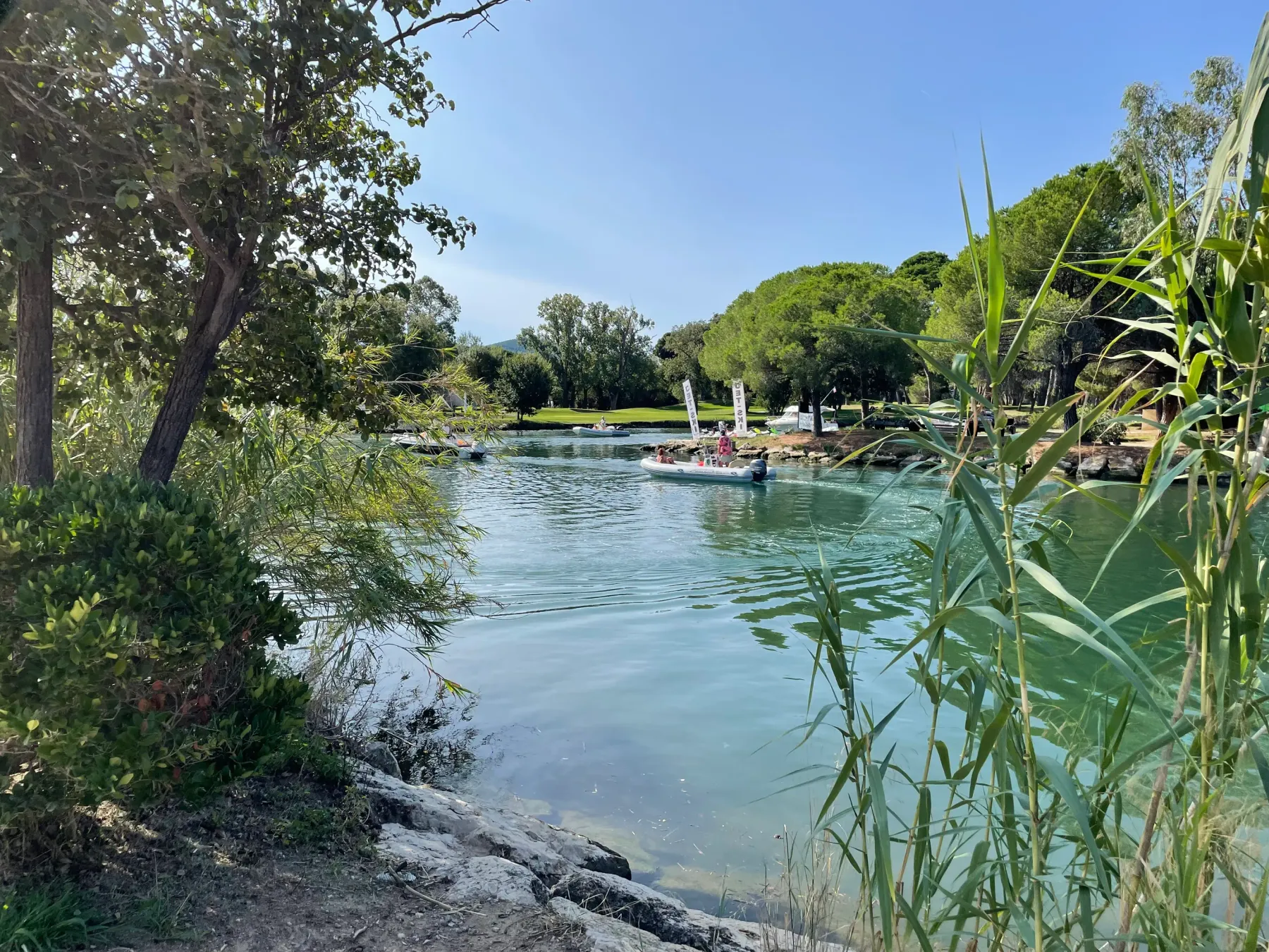 Un plan d'eau entouré de végétation avec des personnes nageant et se relaxant sur des radeaux